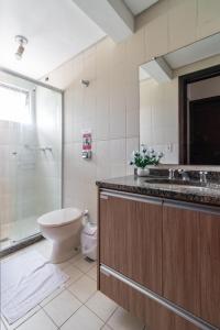 a bathroom with a toilet and a shower and a sink at Family Space Curitiba/vaga de garagem Gratis in Curitiba