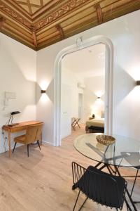 um quarto com uma mesa de vidro e cadeiras e uma cama em LAA Studios em Coimbra