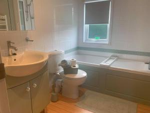 a bathroom with a sink and a toilet and a tub at The Lodge at Haggerston Castle in Beal