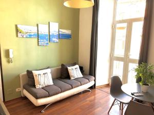 uma sala de estar com um sofá e uma mesa em Maison Plebiscito em Nápoles