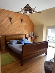 a bedroom with a large bed with a wooden wall at Biologite in Argentré-du-Plessis