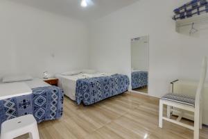 um quarto com duas camas e uma cadeira em Pousada Recanto da Paz em Lindóia