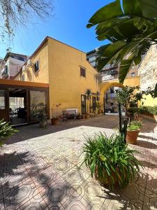 a building with a courtyard with plants in front of it at Hotel d'Orleans in Palermo