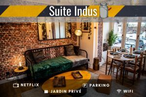 Pokój z kanapą i stołem z jadalnią w obiekcie SUITE INDUS - JARDIN, NETFLIX et PARKING - Le Manoir aux Pommes w mieście Orbec-en-Auge