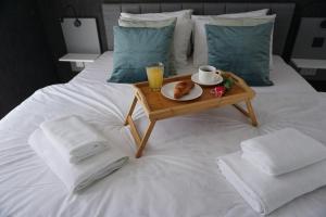 a tray with a plate of food on a bed at KORZO SUITES in Il-Gżira