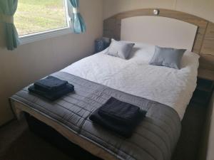 a bedroom with a large bed with two towels on it at Sussex by the sea holiday home in Hastings