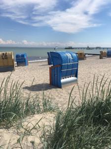 a blue beach chair sitting on a sandy beach at Haus Tanneck, Nr 5 in Kellenhusen