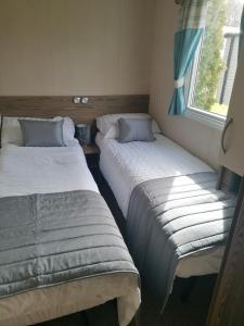 two beds sitting in a room with a window at Sussex by the sea holiday home in Hastings