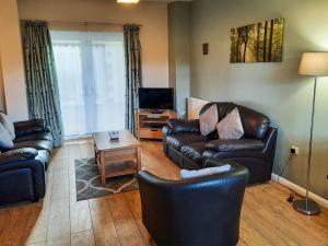 sala de estar con sofás de cuero y TV en Snowdrop Cottage - W43121 en Goxhill