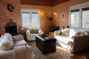 uma sala de estar com mobiliário branco e uma lareira em Passenger Point em Volos