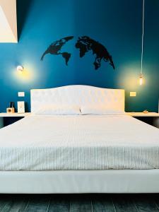 - une chambre avec un grand lit blanc et un mur bleu dans l'établissement Ritorno alla Natura, à Recanati