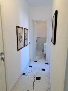 - un couloir avec des murs blancs et du carrelage noir et blanc dans l'établissement Preia de ma, à Levanto