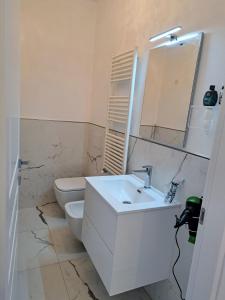 La salle de bains blanche est pourvue d'un lavabo et de toilettes. dans l'établissement Preia de ma, à Levanto