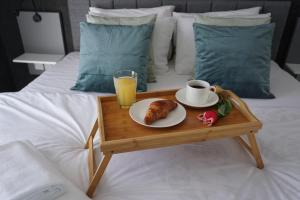 ein Tablett mit einer Tasse Kaffee und einem Teller Essen auf dem Bett in der Unterkunft KORZO SUITES in Gżira