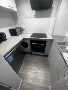 a small kitchen with a stove and a dishwasher at Wellington Apartment in Glasgow