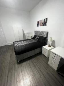 a bedroom with a bed and a white wall at Wellington Apartment in Glasgow