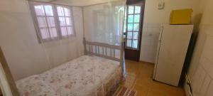 a small bedroom with a bed and a refrigerator at Studio pour 2 personnes au calme en Basse-Terre in Vieux-Habitants