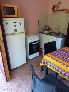 a kitchen with a refrigerator and a table and a microwave at Studio pour 2 personnes au calme en Basse-Terre in Vieux-Habitants