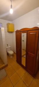 a bathroom with a toilet and a wooden cabinet at Studio pour 2 personnes au calme en Basse-Terre in Vieux-Habitants +3 photos
