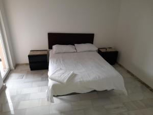 1 dormitorio con 1 cama blanca y 2 mesitas de noche en CASA FLOARE DE COLT, en Sîmbăta de Sus