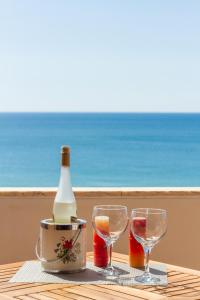 una mesa con dos copas y una botella de vino en Alvor Sun, en Alvor