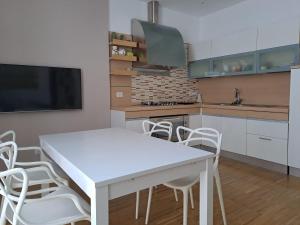 a kitchen with a white table and white chairs at Le Casette in Matera