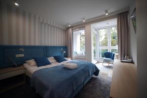 a bedroom with a large bed with a blue head board at Pensjonat Przedwiośnie in Jurata