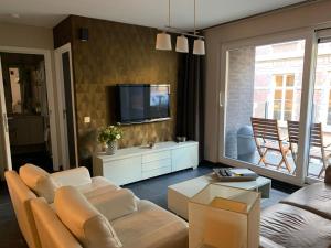 een woonkamer met een bank en een tv bij Littoral105 in Blankenberge