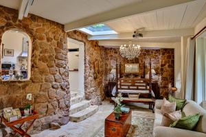 a living room with a large stone wall at MacLeod House Guest Cottage in Kloof
