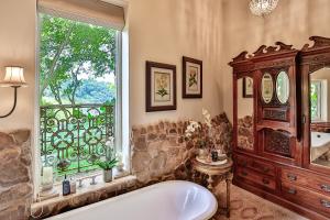 a large bathroom with a tub and a window at MacLeod House Guest Cottage in Kloof