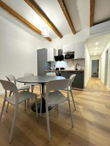una sala da pranzo con tavolo e sedie e una cucina di Happy Family Apartments San Luca a Genova