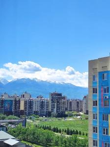 uitzicht op een stad met gebouwen en bergen bij 1 комнатная квартира в ЖК Алмалы,район Алматы Арена in Alma-Ata