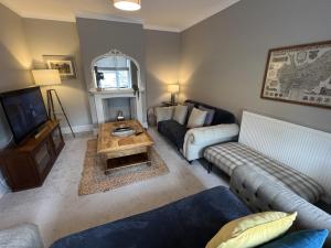 a living room with a couch and a tv at Luxurious Victorian villa with parking sleeps six in Bury Saint Edmunds