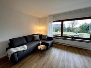 a living room with a black couch and a large window at Wohnglück Seifferer in Ravensburg