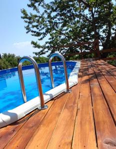 a wooden deck next to a swimming pool at Villa Feluchia Tra Il Mare E Il Vulcano in Acireale