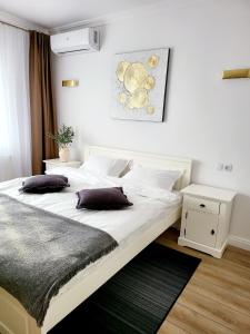 a bedroom with a large white bed with two pillows at Double room - House of Chess in Satu Mare