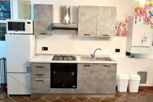 諾瓦拉的住宿－Casa Atelier，厨房配有炉灶、水槽和冰箱。
