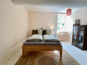 uma cama numa sala com um tapete em Hübsches Landhaus der Familie mit eigenem Garten em Heugueville-sur-Sienne