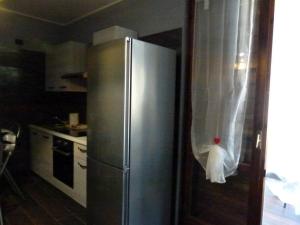 a kitchen with a stainless steel refrigerator with a towel on the door at Appartamento Bel Sito in Bardolino