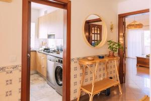een keuken met een wasmachine en een tafel bij Starry Nights Apartment in Albufeira