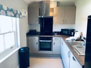 a kitchen with a sink and a stove top oven at Three Warehouse Apartments in Ulverston