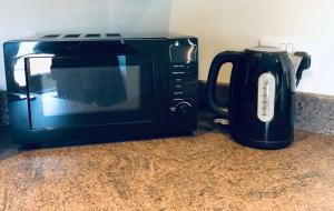 a microwave sitting on a counter next to a coffee pot at Three Warehouse Apartments in Ulverston