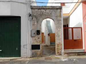 une arche sur le côté d'un bâtiment avec une porte verte dans l'établissement Casa Bianca, à Gagliano del Capo