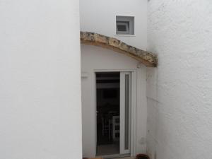 une ouverture dans un mur blanc avec une porte dans l'établissement Casa Bianca, à Gagliano del Capo