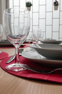 einen Tisch mit einem Glas Wein auf einer roten Serviette in der Unterkunft Júlio de Matos Guest House in Porto