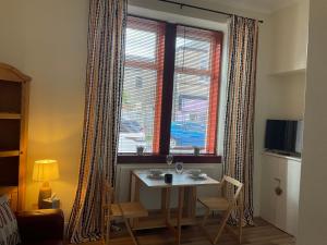 a table and chairs in a room with a window at Hillview, Ground floor apartment, Largs in Largs