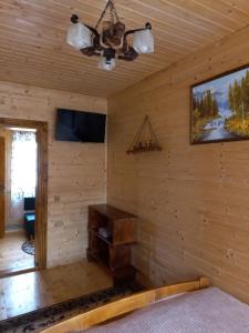 a room in a log cabin with a television and a table at Котедж "Затишний відпочинок" in Huklyvyy