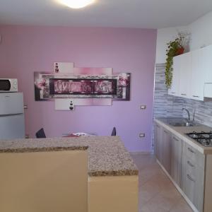 a kitchen with purple walls and a counter top at La Fortezza casa vacanze & appartament in Castelsardo
