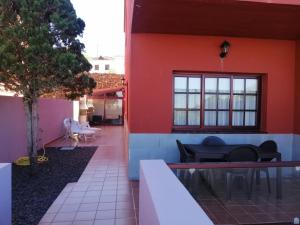 una casa con una pared roja y un patio en Idílico adosado en El Mocanal en Mocanal