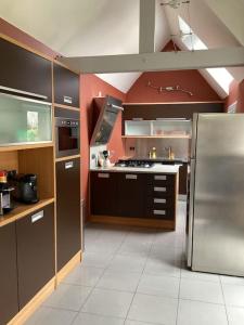 La cuisine est équipée d'un réfrigérateur et de placards en acier inoxydable. dans l'établissement LE GITE LACHELLE, à Lachelle
